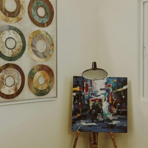 A vibrant art display featuring paintings on a white wall in a Bengaluru home.