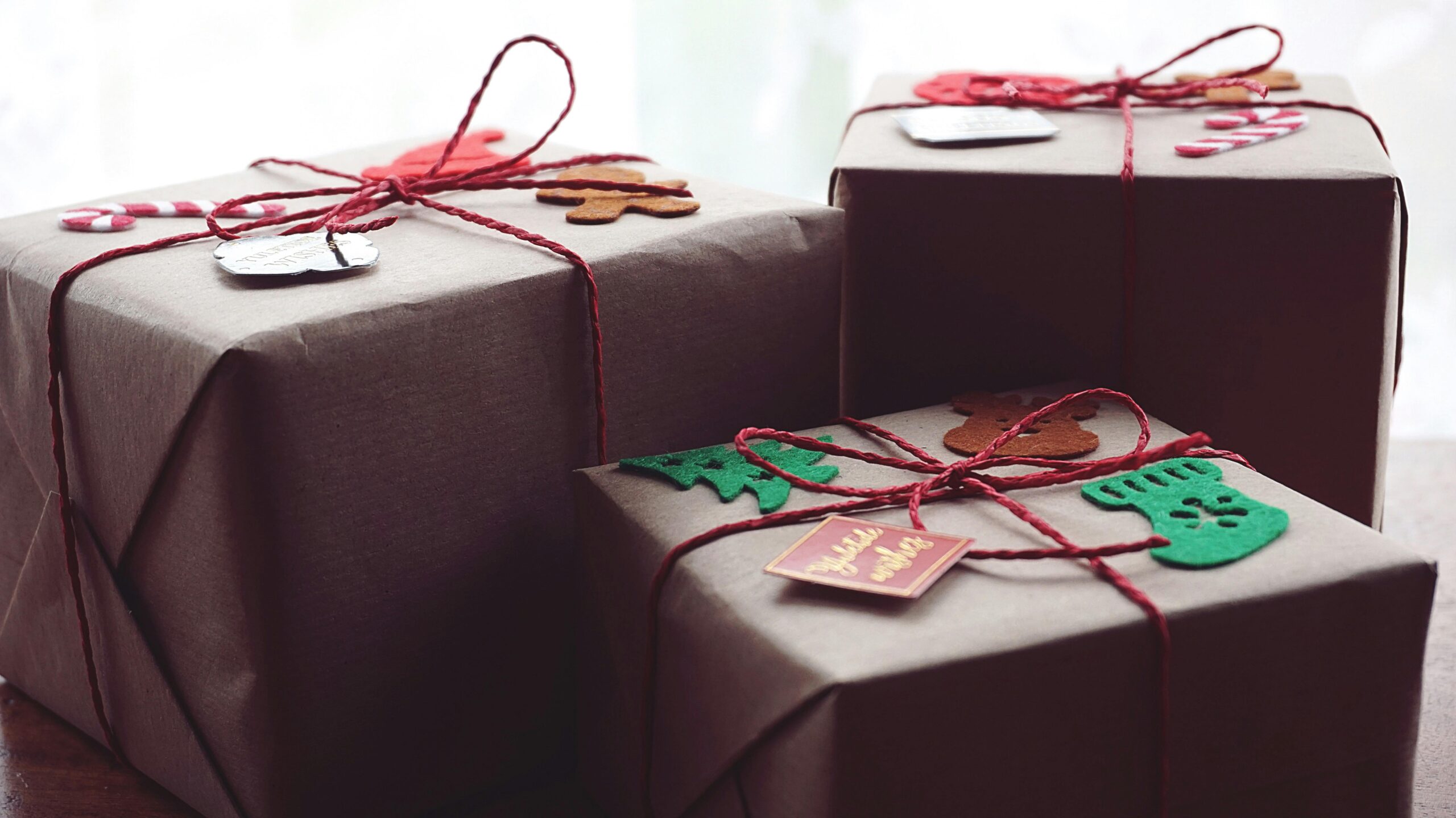 pexels photo 1661965 1661965 Three beautifully wrapped holiday gift packages with festive decorations.