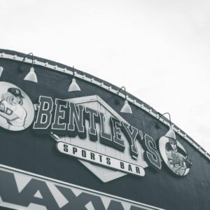 Black and white image of Bentley's Sports Bar sign with baseball theme.