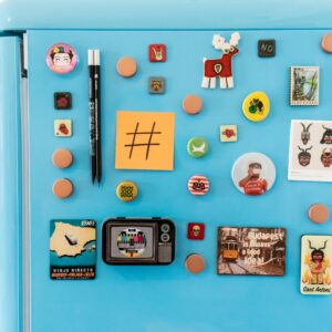 A vibrant collection of fridge magnets and notes on a blue refrigerator with ample copy space.