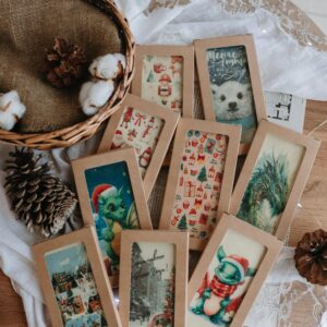 A selection of festive greeting cards with rustic decorations including pine cones and cotton in a wicker basket.