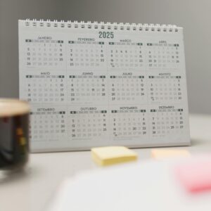 A clean and organized desk setup with a 2025 calendar and sticky notes, perfect for planning.