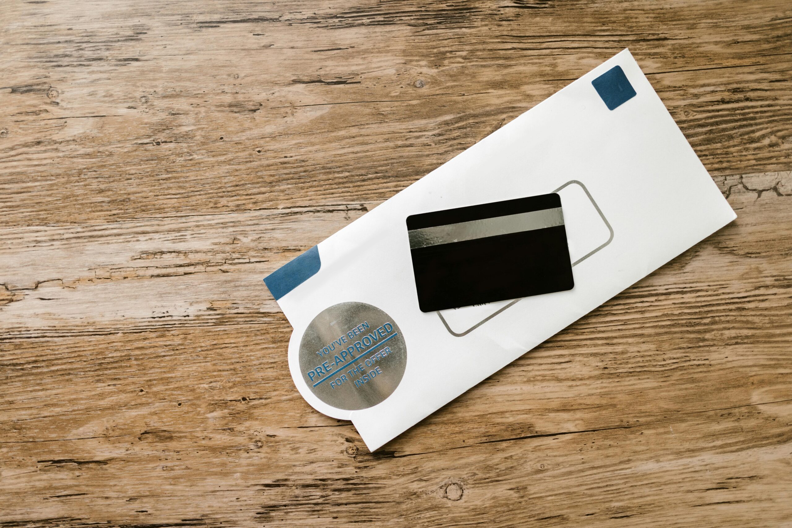 pexels photo 7821482 7821482 A blank credit card with a pre-approved envelope on a wooden table, showcasing financial opportunities.