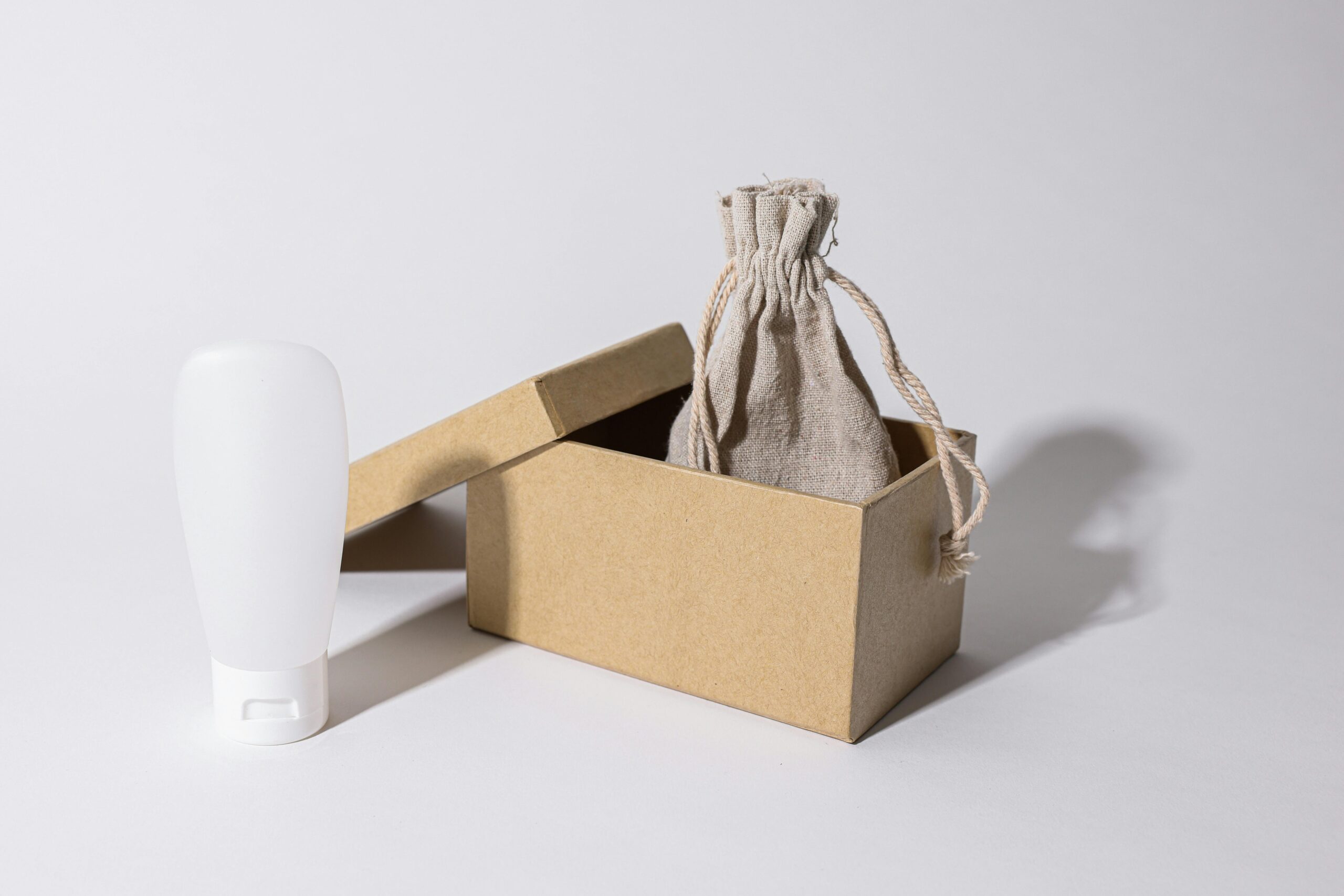 pexels photo 8015893 8015893 Minimalist photo of eco-friendly packaging with a cardboard box, pouch, and white plastic bottle.