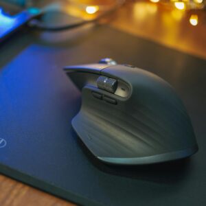 Stylish ergonomic wireless mouse on a sleek black mouse pad with ambient lighting.